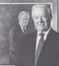 Photo of Dr. David Baker in front of his painted portrait.